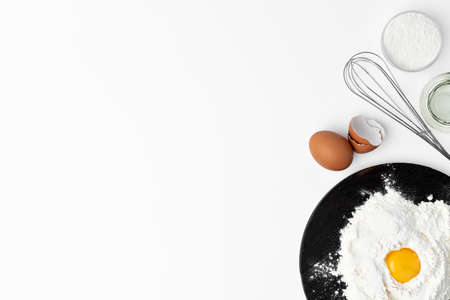 Metal whisk and eggs for cooking isolated on white backgroundの写真素材