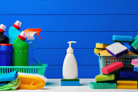Various cleaning items against blue wooden background, front viewの写真素材