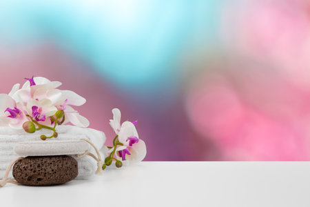 Towels with flowers on light table against blurred backgroundの写真素材