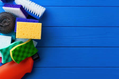 Household cleaning supplies on blue wooden background flat layの写真素材
