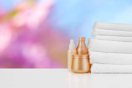 Spa still life with towels and skincare cosmetics against blurred backgroundの写真素材