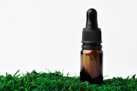 Bottle of aromatic oil for herbal medicine among natural green mossの写真素材