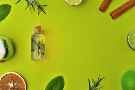 Herbal essential oil bottles flat lay on green background