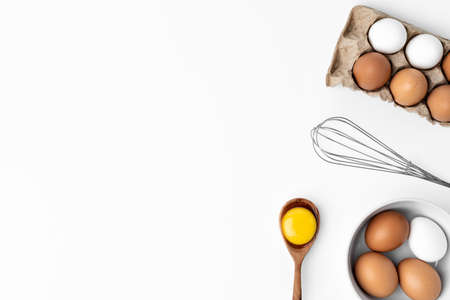Fresh eggs with whisk isolated on white backgroundの写真素材