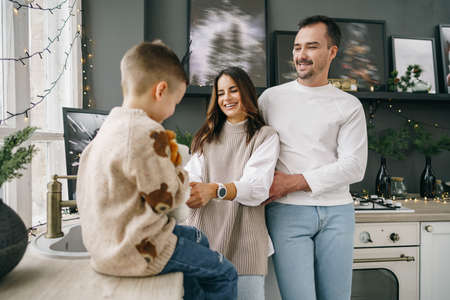 A portrait of happy family in the kitchen decorated for Christmasの写真素材
