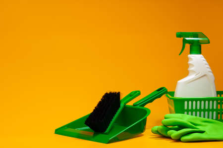 Home cleaning tools on yellow studio background