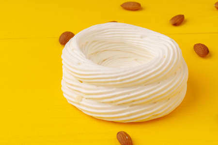 Whipped cream meringue dessert on yellow backgroundの写真素材