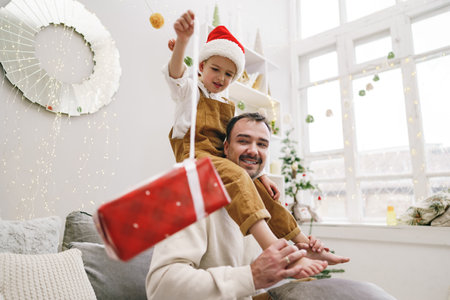 Young dad and his son celebrate christmas togetherの写真素材