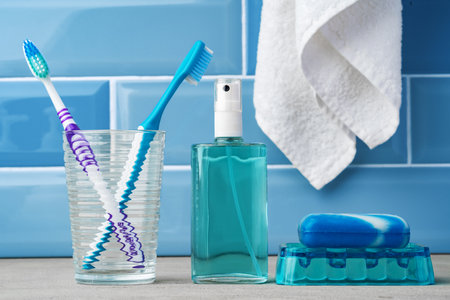 The toothbrushes in a glass in blue bathroom.の写真素材