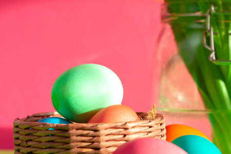 Vibrant colored eggs in a nest on green. Easter concept