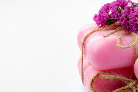 Pink bars of handmade natural soap and flowers isolated on white