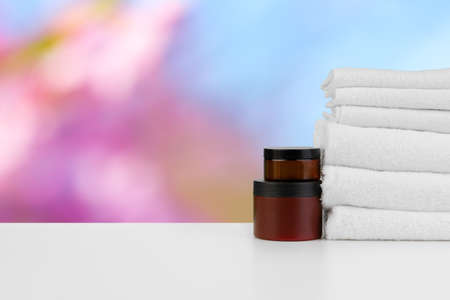 Spa still life with towels and skincare cosmetics against blurred backgroundの写真素材