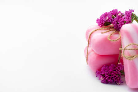 Pink bars of handmade natural soap and flowers isolated on whiteの写真素材