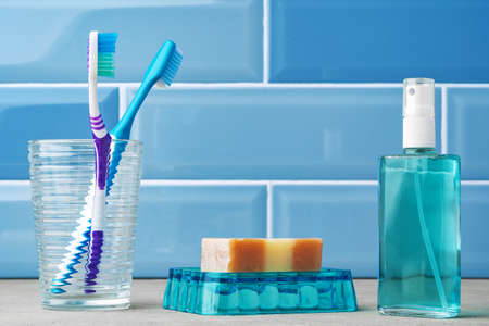 The toothbrushes in a glass in blue bathroom.の写真素材
