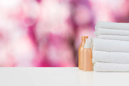 Spa still life with towels and skincare cosmetics against blurred backgroundの写真素材