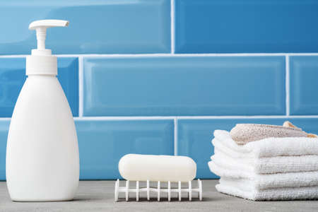 Soap and toiletries on shelf in blue bathroomの写真素材