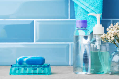 Soap and toiletries on shelf in blue bathroomの写真素材