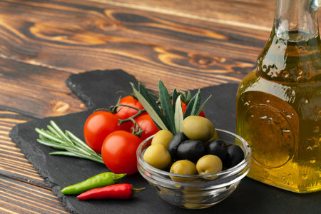 Olive oil, olives and tomatoes on wooden backgroundの写真素材