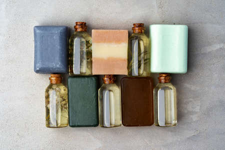 Bottles of essential oil and soap bars on gray backgroundの写真素材