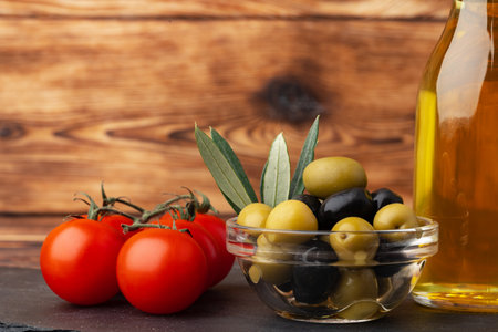 Olive oil, olives and tomatoes on wooden backgroundの写真素材
