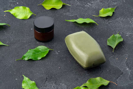 Natural soap and green leaves on dark gray backgroundの写真素材