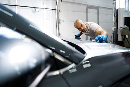 African American man car service worker applying nano coating on a carの写真素材