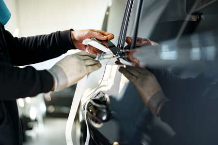 Close up of male car service worker applying nano coating on a carの写真素材