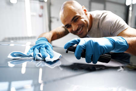 African American man car service worker applying nano coating on a carの写真素材