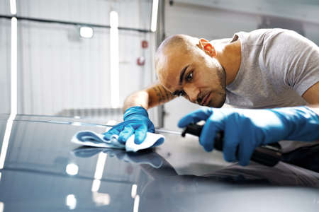 African American man car service worker applying nano coating on a car