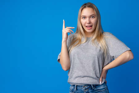 Portrait of pretty teen girl thinking and creating solution against blue backgroundの写真素材