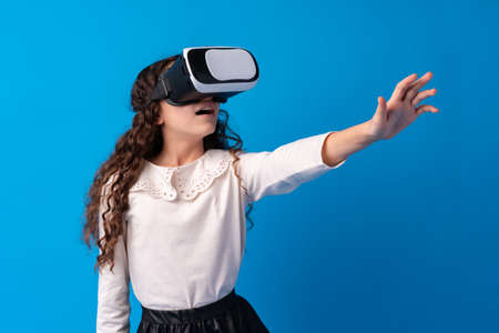 Girl with virtual reality glasses on blue background.