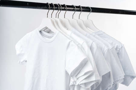 Clothes hang on clothing rack over white background.の写真素材
