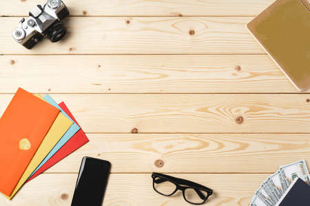 Working place with envelopes, camera, glasses and smartphone on wooden table top viewの写真素材