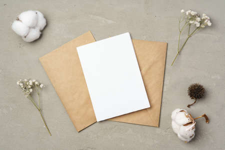 Flowers, blank paper and envelope on a table top