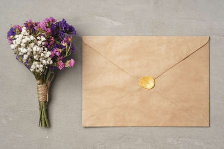 Top view of flower bouquet and craft envelope on gray surface flat layの写真素材