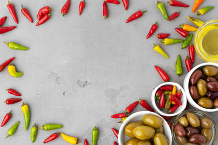 Composition with chili peppers, olives and olive oil on gray backgroundの写真素材