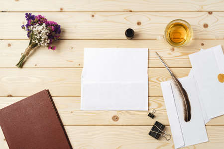 Flowers, blank paper and envelope on a table topの写真素材