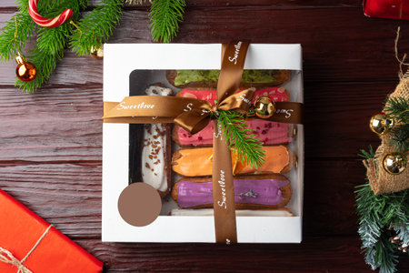Box of colorful eclairs on Christmas background