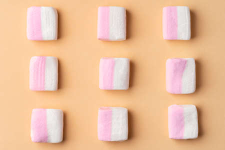 Fluffy marshmallows on beige studio background, top viewの写真素材