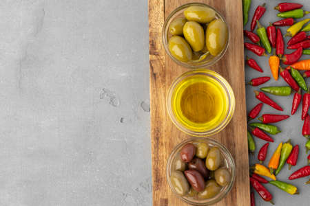 Bowl with green olives and olive leaves on white background, top viewの写真素材