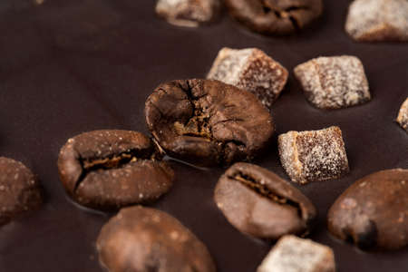 Close up of dark chocolate bar with coffee beans and candied fruitの写真素材