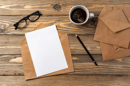 Vintage envelope with empty card, pen on wooden table top viewの写真素材