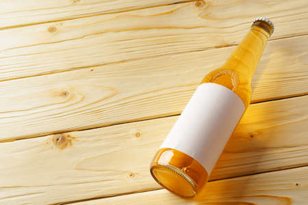 Beer bottle on a brown wooden table flat lay background with a copy spaceの写真素材