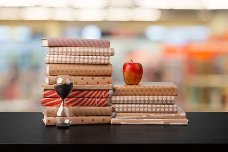 Stack of books on wooden table against blurred backgroundの写真素材