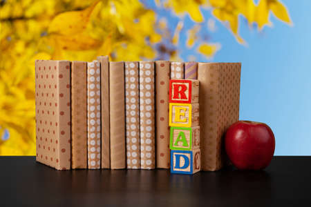 Stack of books on wooden table against blurred backgroundの写真素材