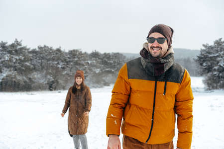 Young couple in love outdoor in snowy winter forest.