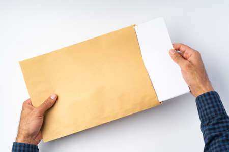 Top view of male hands hold (open) an envelope above white background