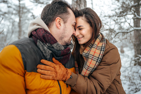 Young couple in love outdoor in snowy winter forest.