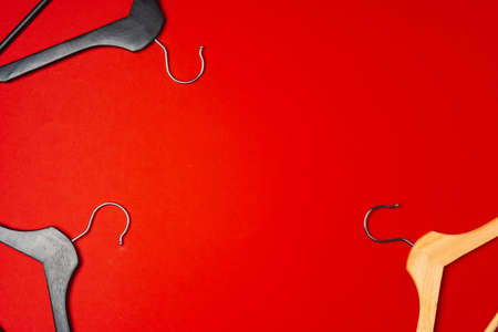 Hanger on red paper background. Minimalistic fashion concept. Top viewの写真素材