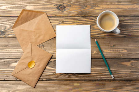 Vintage envelope with empty card, pen on wooden table top view